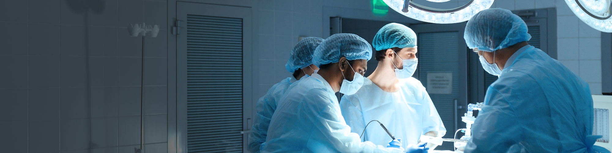 Vier Personen in einem OP-Saal während einer Operation